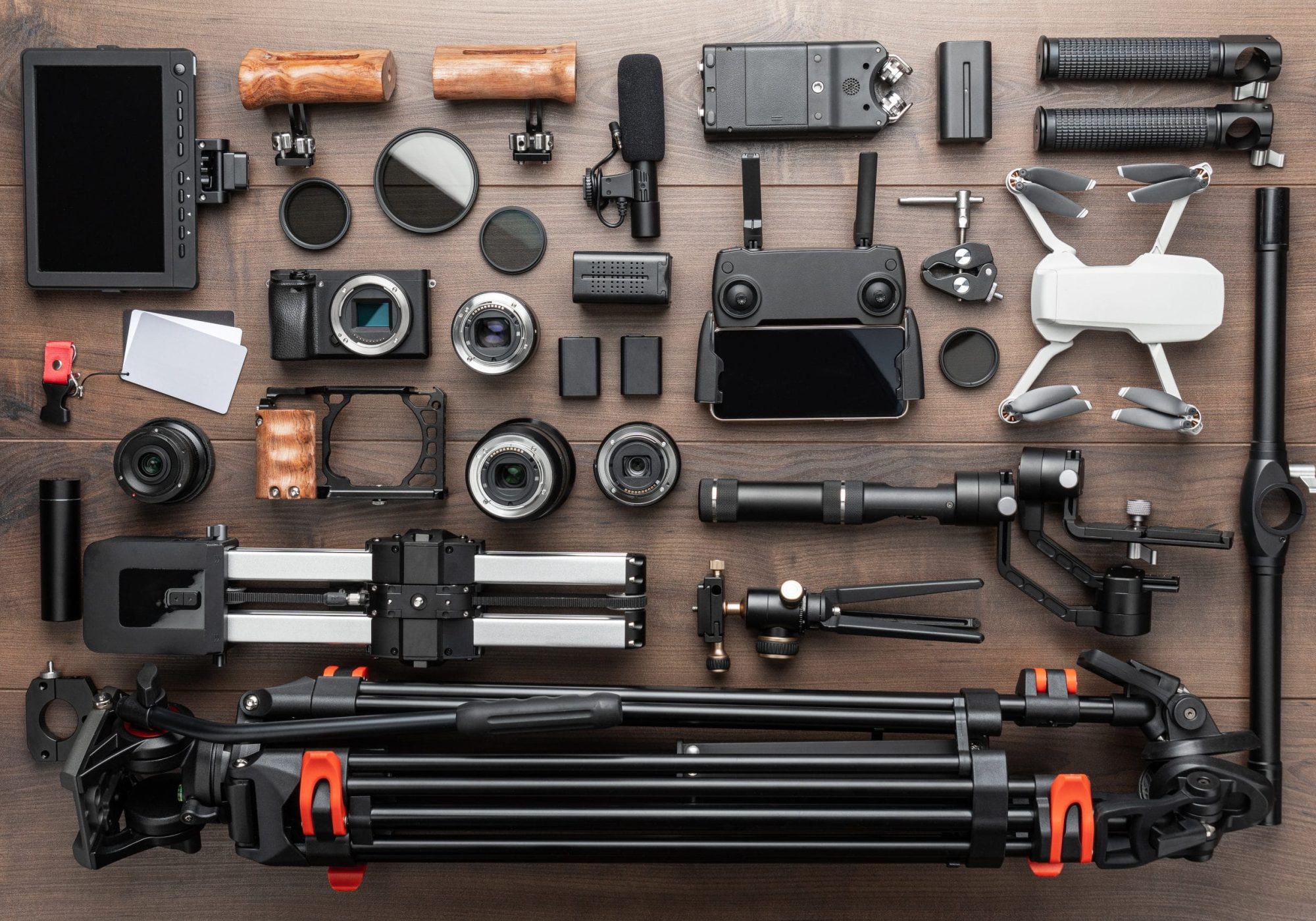 Different video making equipment for indie cinema production. Video production tools on brown wooden table view from above. Short movie production essentials.